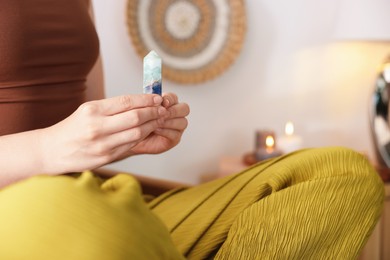 Photo of Woman with beautiful fluorite gemstone indoors, closeup. Space for text
