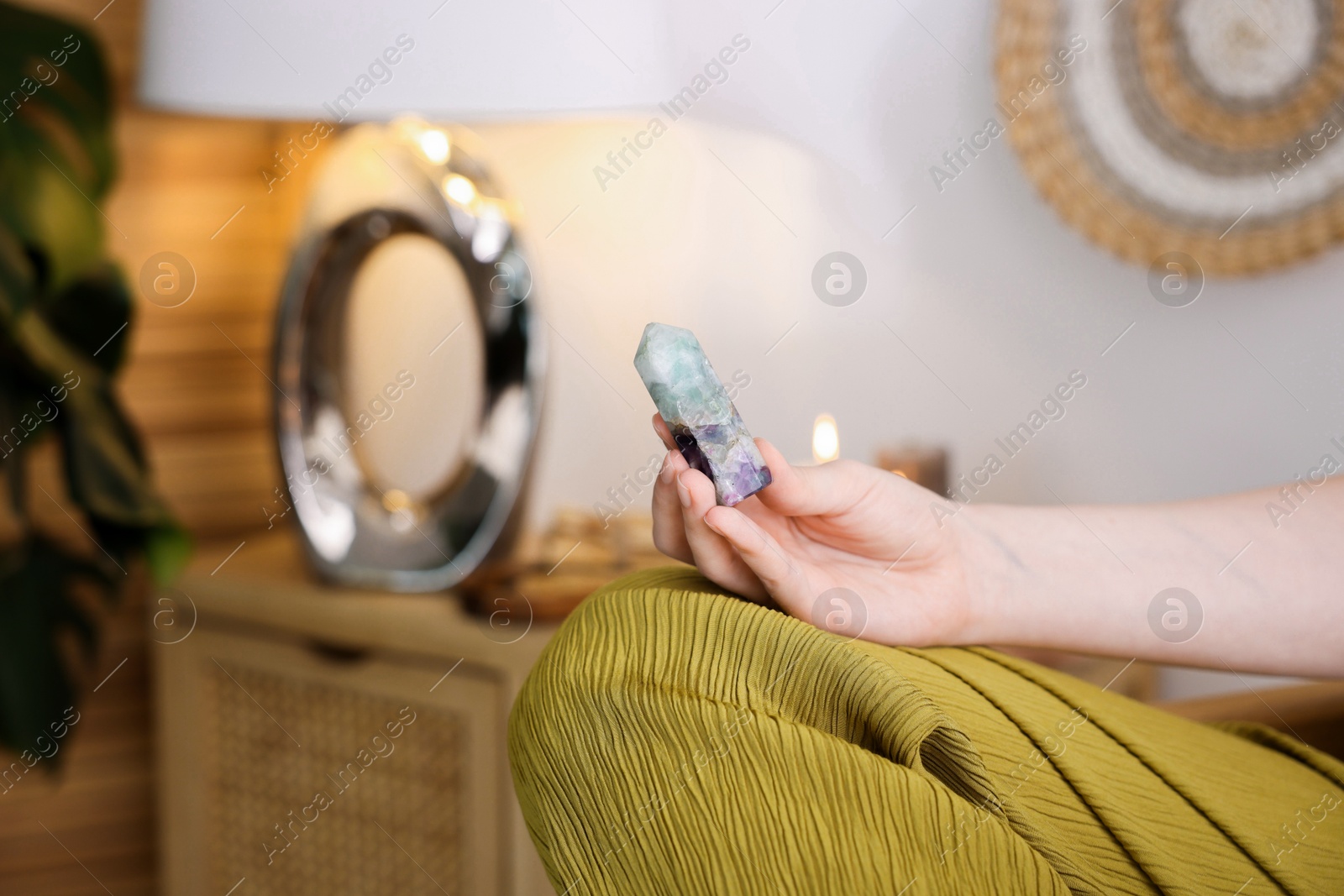 Photo of Woman with beautiful fluorite gemstone indoors, closeup. Space for text