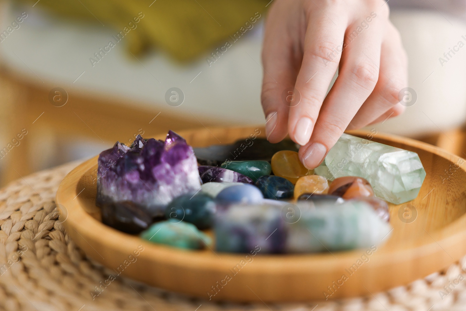Photo of Woman with different beautiful gemstones indoors, closeup