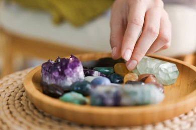 Photo of Woman with different beautiful gemstones indoors, closeup