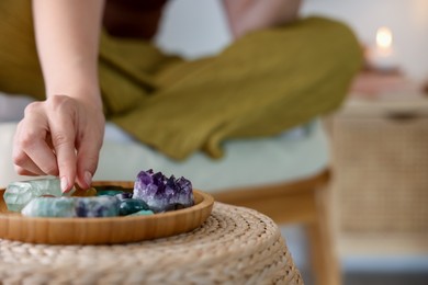 Photo of Woman with different beautiful gemstones indoors, closeup. Space for text