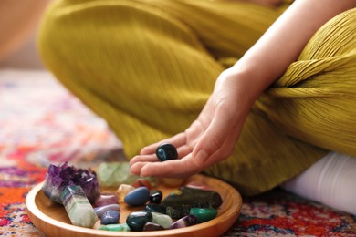 Photo of Woman with different beautiful gemstones indoors, closeup