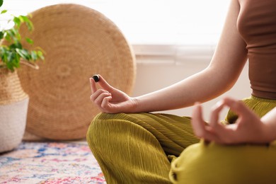 Photo of Woman with beautiful gemstones meditating indoors, closeup. Space for text