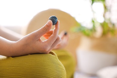 Photo of Woman with beautiful gemstones meditating indoors, closeup. Space for text