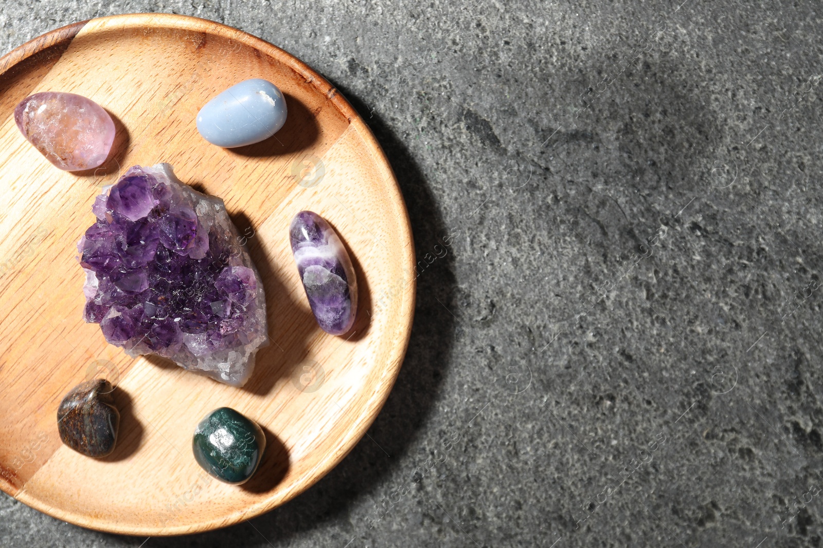 Photo of Different beautiful gemstones on grey table, top view. Space for text