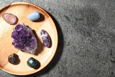 Photo of Different beautiful gemstones on grey table, top view. Space for text