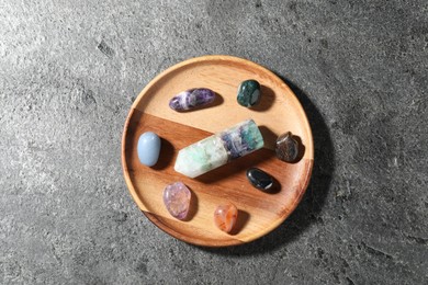 Photo of Different beautiful gemstones on grey table, top view