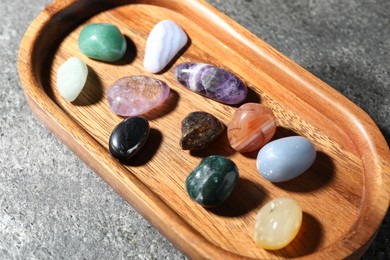 Photo of Different beautiful gemstones on grey table, closeup