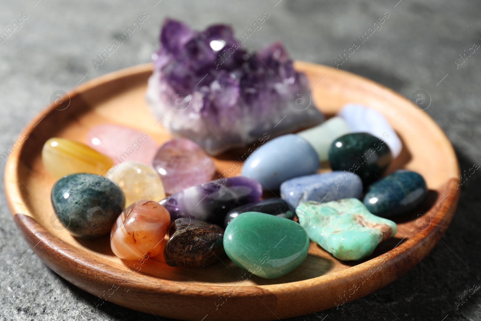 Photo of Different beautiful gemstones on grey table, closeup