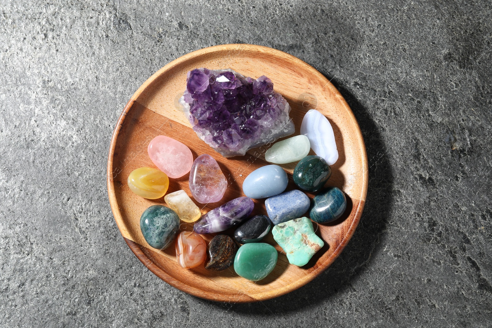 Photo of Different beautiful gemstones on grey table, top view