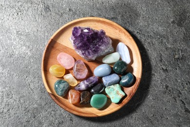 Photo of Different beautiful gemstones on grey table, top view