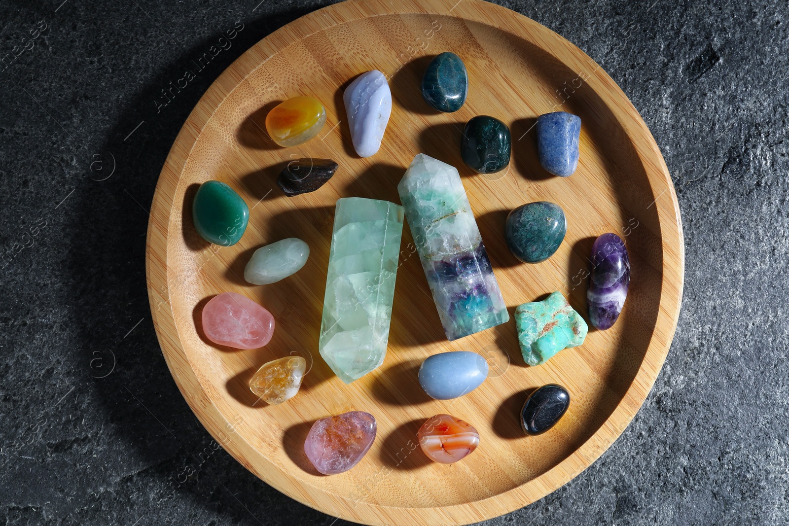 Photo of Different beautiful gemstones on grey table, top view
