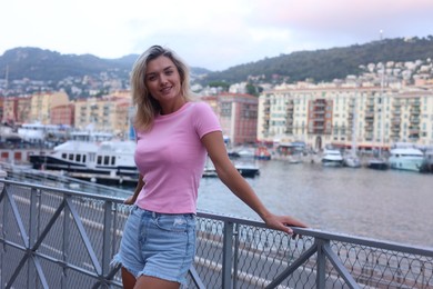 Photo of Portrait of happy young woman near canal outdoors, space for text