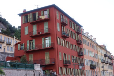 Photo of Beautiful buildings with windows in city against blue sky, low angle view