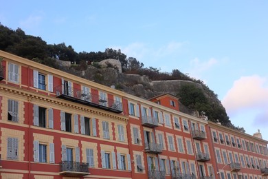 Photo of Beautiful building with windows in city against blue sky, low angle view