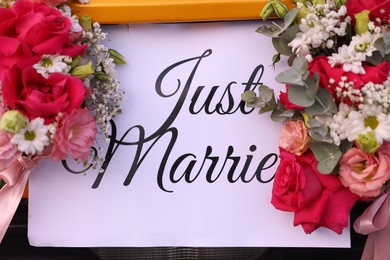 Photo of Wedding car. Cabriolet decorated with Just Married card and beautiful flowers outdoors, closeup
