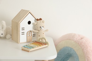 Photo of Different toys and table near white wall