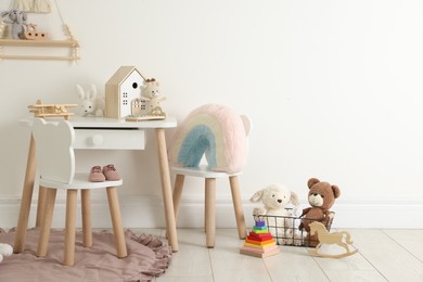 Photo of Different cute toys and furniture in child's room. Space for text