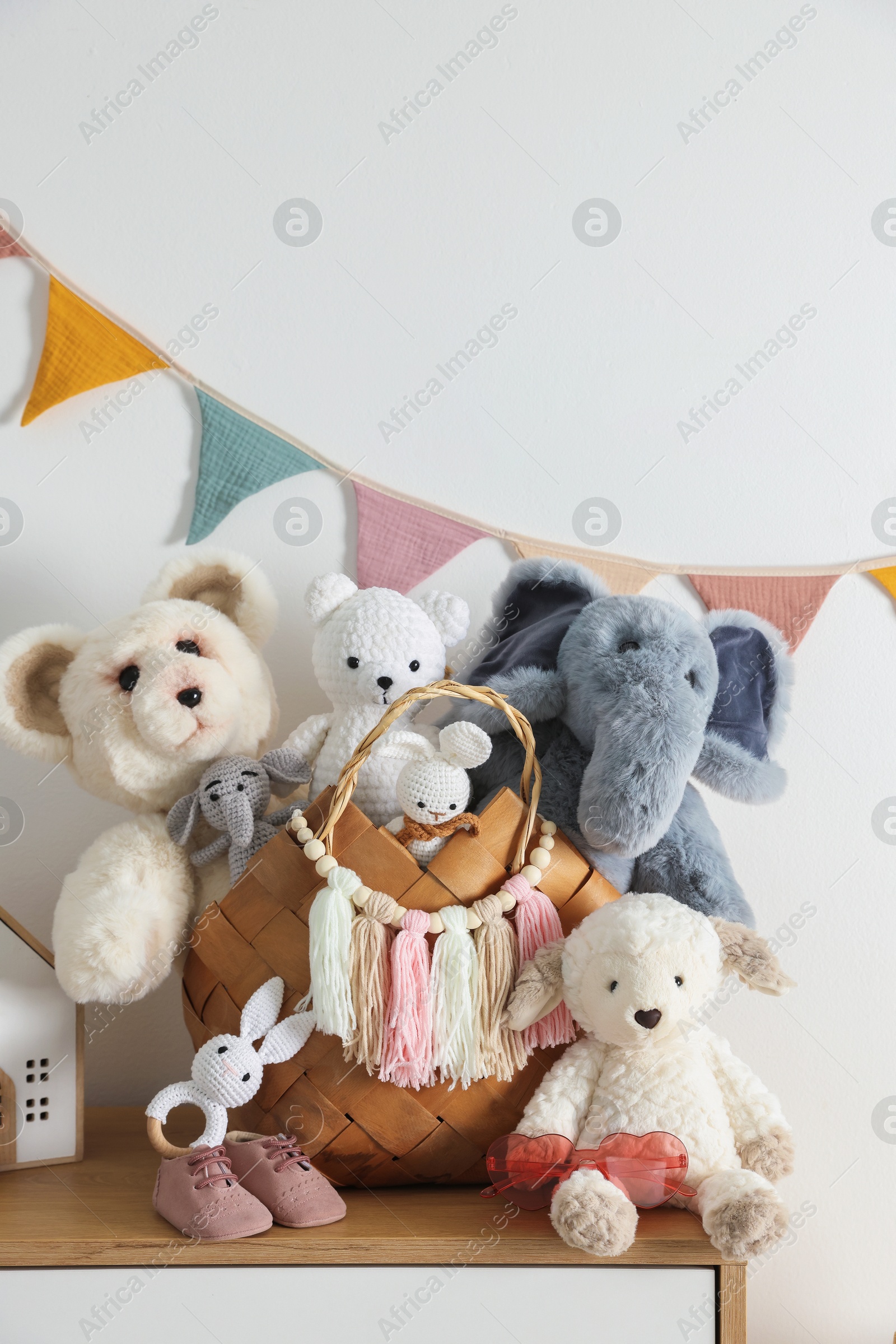 Photo of Different toys on chest of drawers near white wall indoors