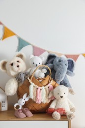 Photo of Different toys on chest of drawers near white wall indoors