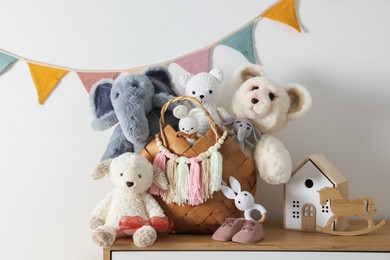 Photo of Different toys on wooden table near white wall indoors