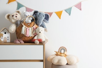 Photo of Different toys on chest of drawers near white wall indoors. Space for text