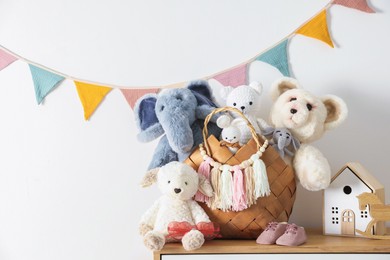 Photo of Different toys on wooden table near white wall indoors