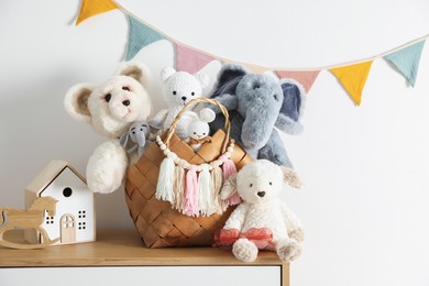 Photo of Different toys on wooden table near white wall indoors