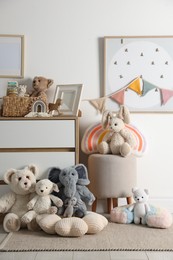 Photo of Different cute toys, furniture and garland in child's room