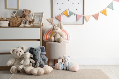 Photo of Different cute toys, furniture and garland in child's room. Space for text
