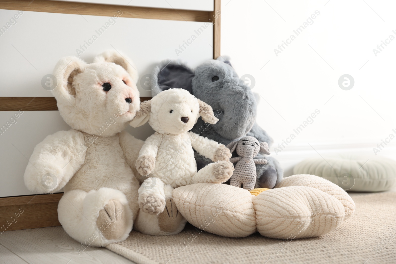 Photo of Different cute soft toys on floor indoors