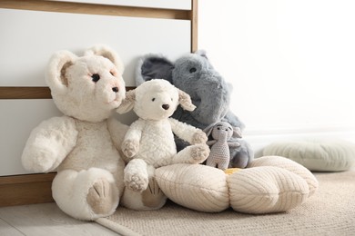 Photo of Different cute soft toys on floor indoors