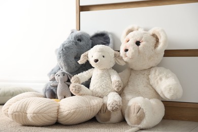 Photo of Different cute soft toys on floor indoors