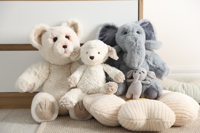 Photo of Different cute soft toys on floor indoors