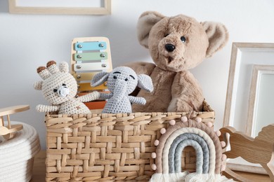 Photo of Different cute toys and decor on table near white wall