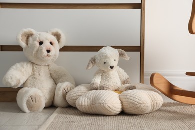 Photo of Different cute soft toys on floor in room