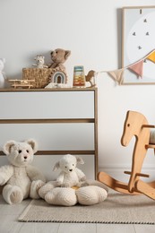 Photo of Different cute toys, furniture and garland in child's room