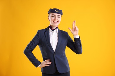 Photo of Charming stewardess in uniform on yellow background