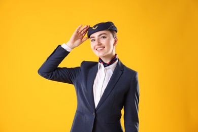 Photo of Charming stewardess in uniform on yellow background