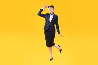 Photo of Charming stewardess in uniform on yellow background