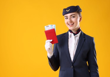 Photo of Smiling stewardess with passport and tickets on yellow background. Space for text