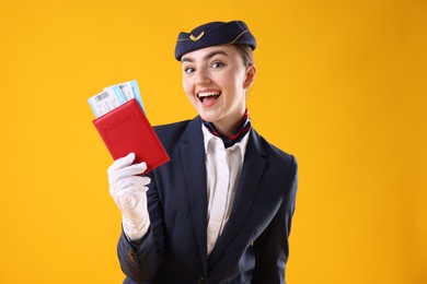 Photo of Excited stewardess with passport and tickets on yellow background