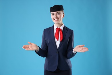 Photo of Positive stewardess doing pre-flight safety briefing on light blue background