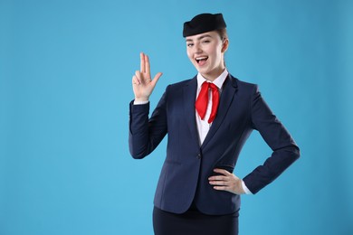 Photo of Charming stewardess in uniform on light blue background. Space for text