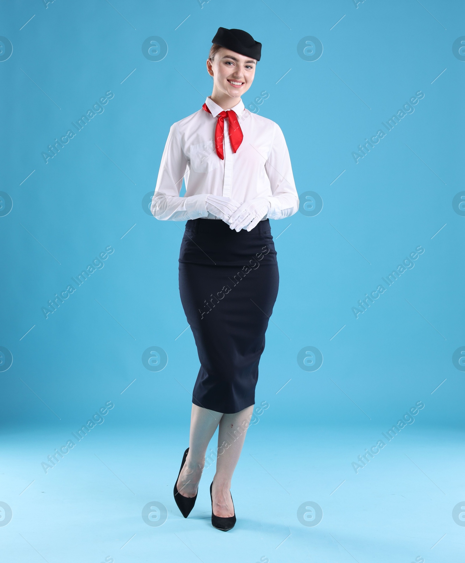 Photo of Charming stewardess in uniform on light blue background