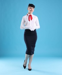 Photo of Charming stewardess in uniform on light blue background