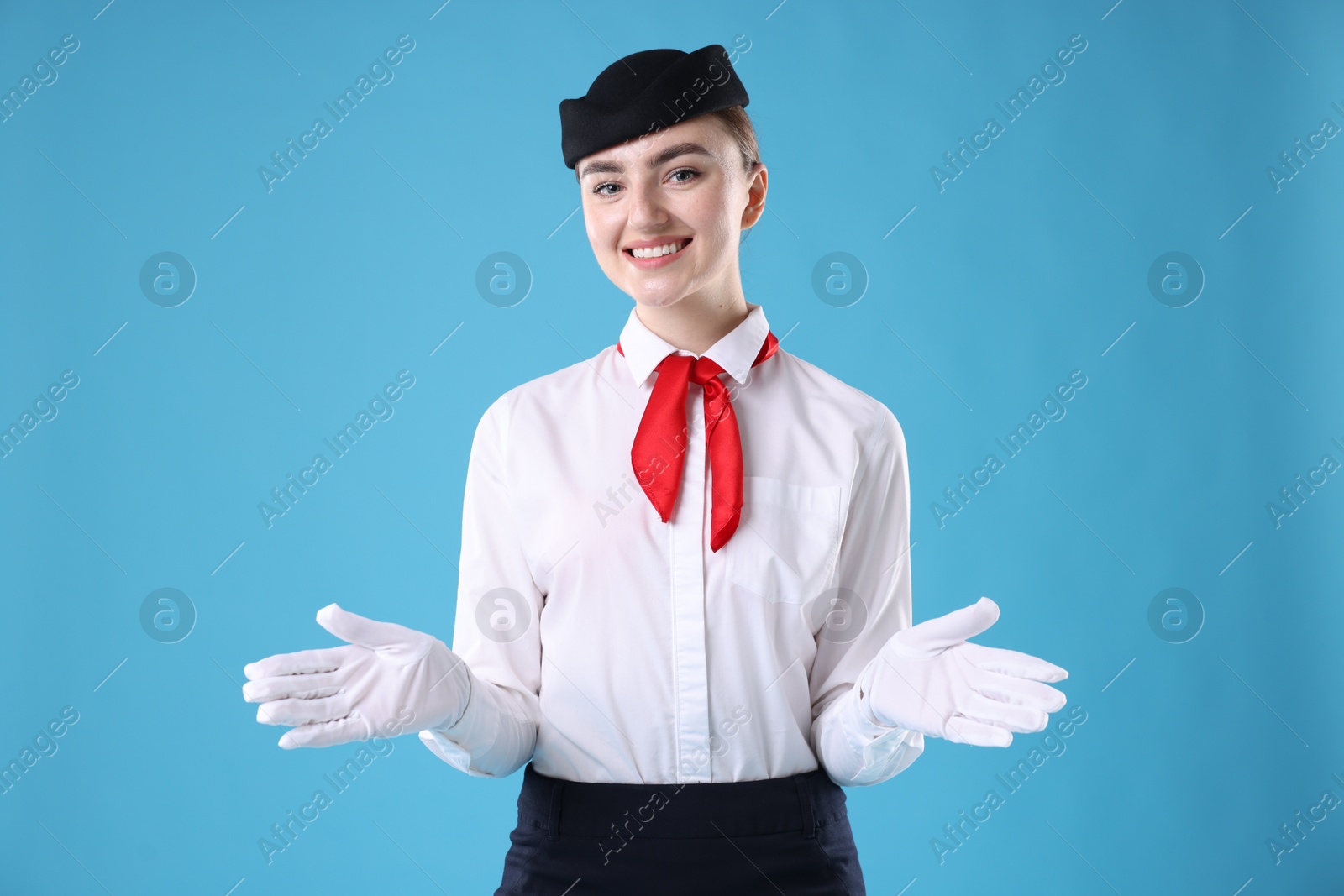 Photo of Positive stewardess doing pre-flight safety briefing on light blue background