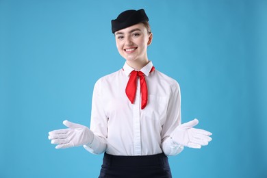 Photo of Positive stewardess doing pre-flight safety briefing on light blue background