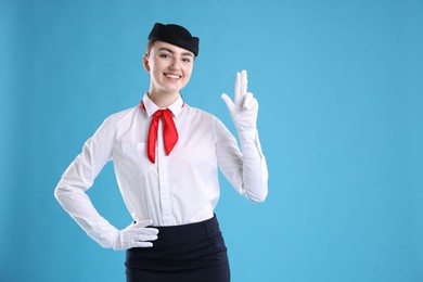 Photo of Charming stewardess in uniform on light blue background. Space for text