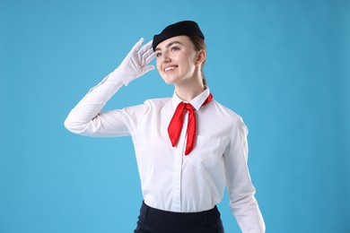 Photo of Charming stewardess in uniform on light blue background